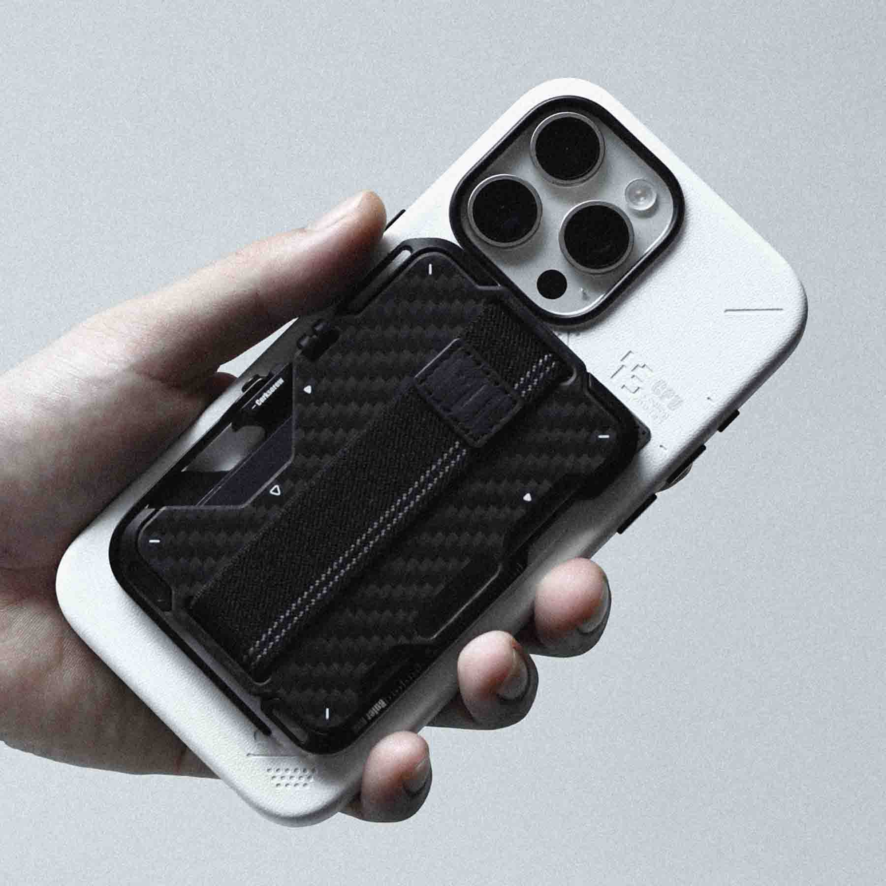 aulumu G03 カーボンファイバーカバーウォレットを装着したiPhoneを手に持つライフスタイルショット プレミアムなアルミ合金フレームとカーボンカバーの質感を強調