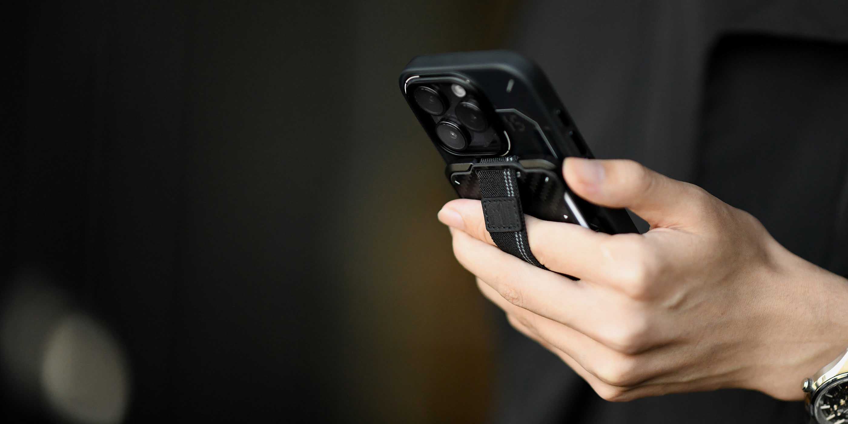 aulumu G03 カーボンファイバーカバーウォレットを装着したiPhoneを片手で持つライフスタイルショット 伸縮ストラップでしっかりグリップできる超薄型コンパクトデザイン