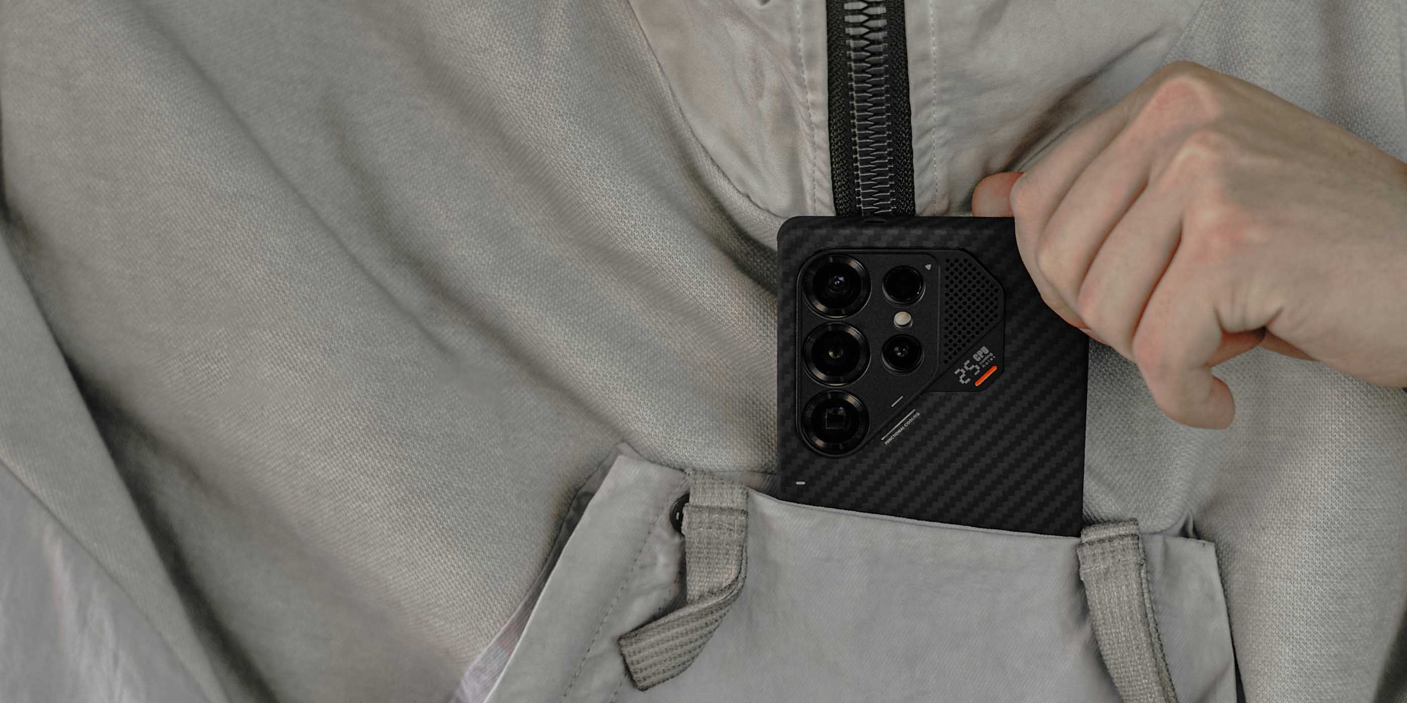 aulumu S25 Aramid Fiber Caseを装着したGalaxy S25 Ultraをジャケットの胸ポケットに入れるシーン アルミカメラリングと突起したフレームで擦り傷から保護する様子