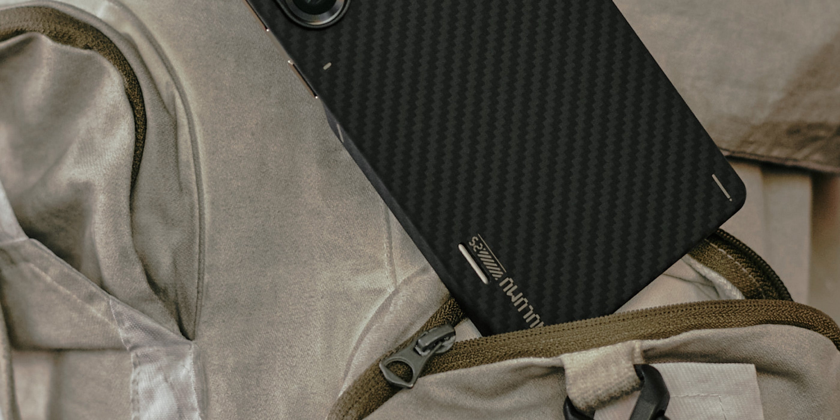 aulumu S25 Aramid Fiber Caseを装着したGalaxy S25 Ultraをバッグのポケットに差し込んだライフスタイルショット スリムなアラミド繊維背面で持ち運びやすいデザイン