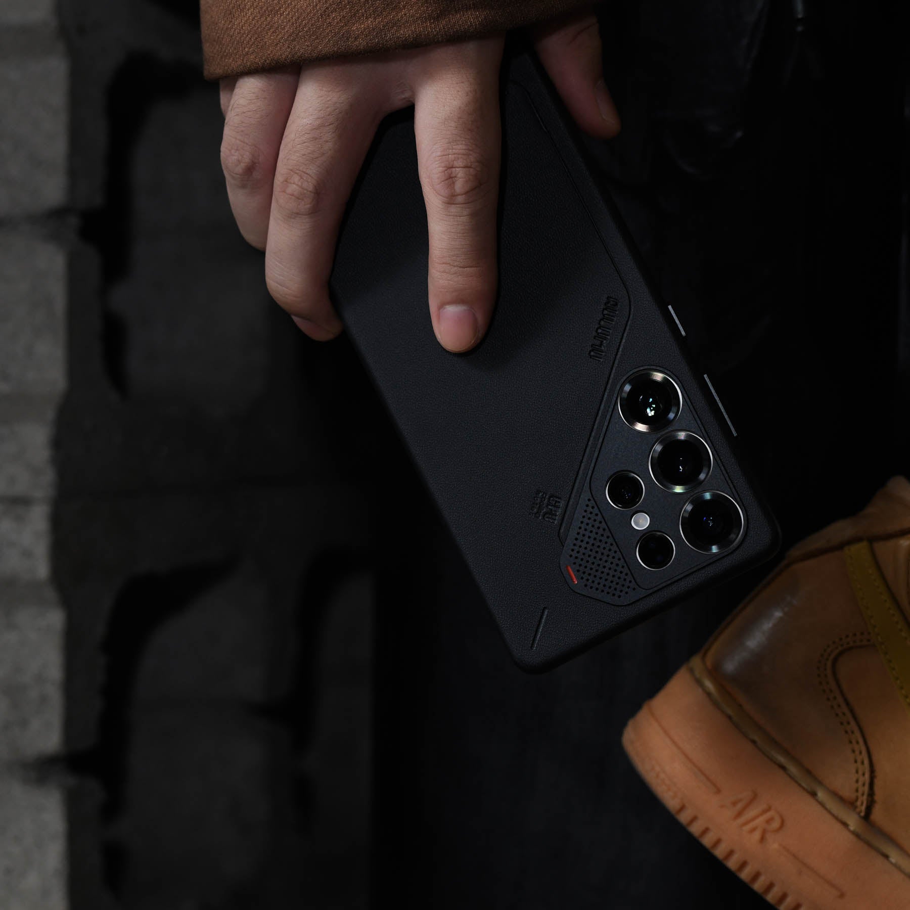 aulumu S25 Vegan Leather Caseを装着したGalaxy S25 Ultraを手に持つライフスタイルショット アルミニウム合金カメラリングがレンズ全体を保護する様子