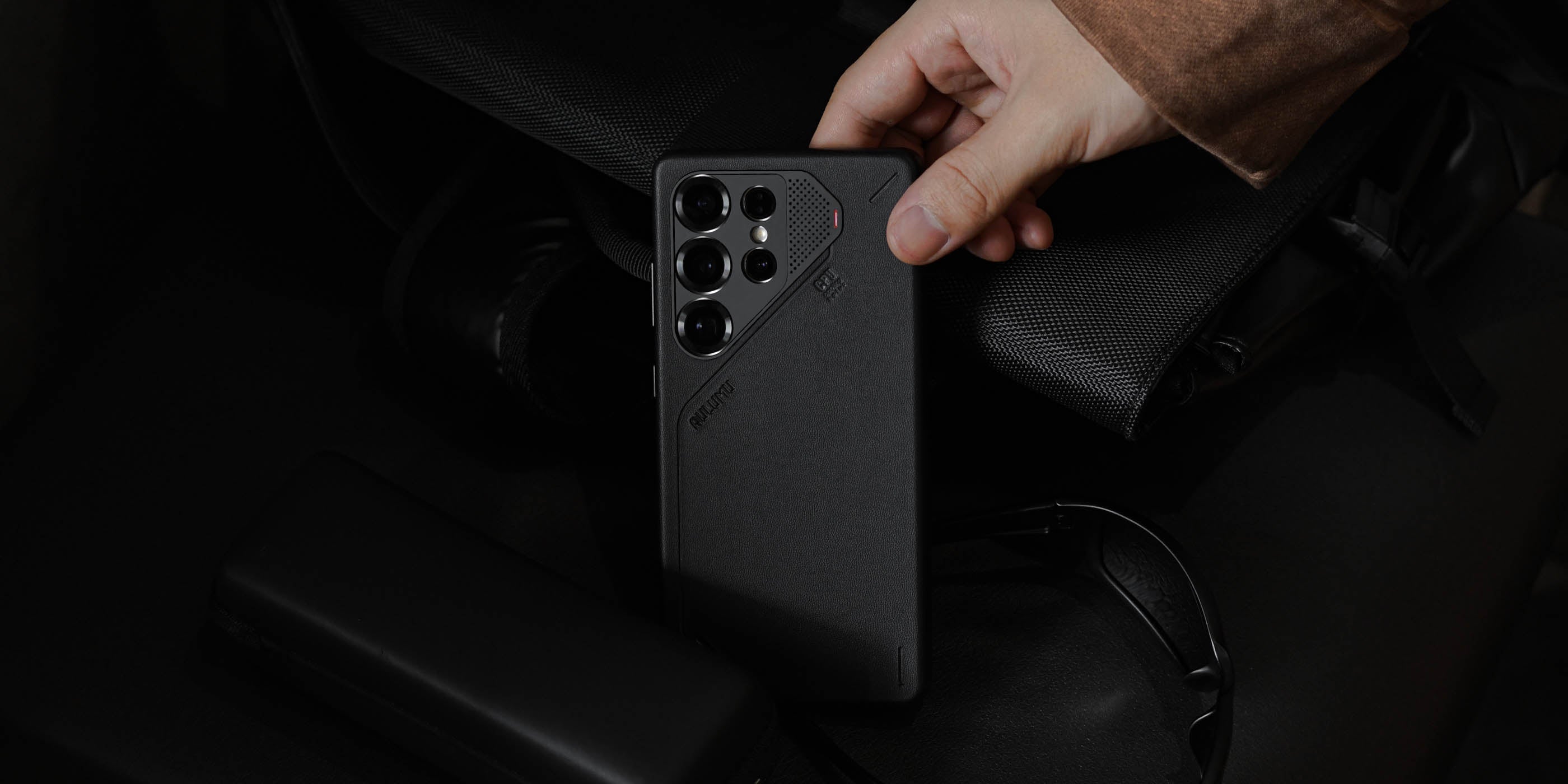 aulumu S25 Vegan Leather Caseを装着したGalaxy S25 Ultraをバッグから取り出すシーン ブラックのヴィーガンレザーとミニマルデザインが際立つライフスタイルショット